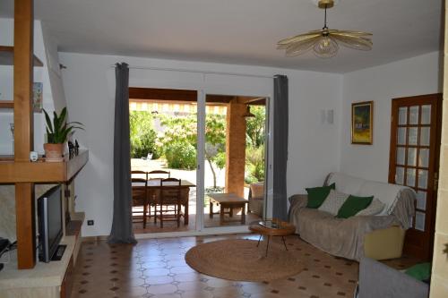 un salon avec un canapé et une table dans l'établissement Maison rénovée avec terrasse privative et jardin au centre de Gemenos, à Gémenos