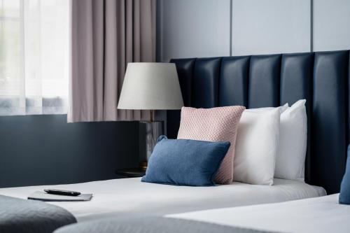 a hotel room with a bed with a pillow and a lamp at St Martins Lodge in Leicester
