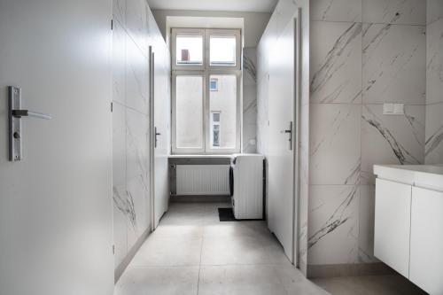 une salle de bains blanche avec une fenêtre et un radiateur dans l'établissement Dream Aparts - Piotrkowska 109, à Łódź