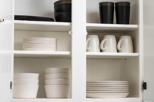 a white cabinet filled with dishes and plates at Denver Emerald - Close to Red Rocks, Arvada & Downtown in Denver
