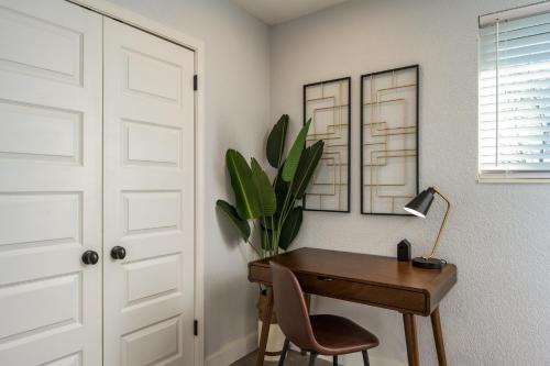 a desk with a lamp and a plant next to a door at Denver Emerald - Close to Red Rocks, Arvada & Downtown in Denver