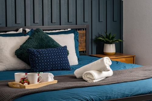 a blue bed with towels and mugs on it at Denver Emerald - Close to Red Rocks, Arvada & Downtown in Denver