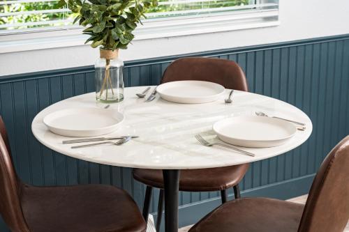 a white table with chairs and a vase of flowers on it at Denver Emerald - Close to Red Rocks, Arvada & Downtown in Denver
