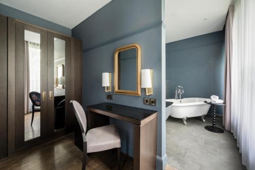 a bathroom with a tub and a sink and a mirror at St Martins Lodge in Leicester