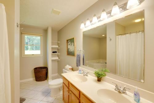 a bathroom with a sink and a toilet and a mirror at Smith Mountain Lake Home with Private Hot Tub and Dock in Moneta