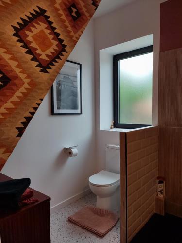 une salle de bain avec toilettes et fenêtre dans l'établissement Le Petit Bivouac, à Saint-Bauzille-de-Putois