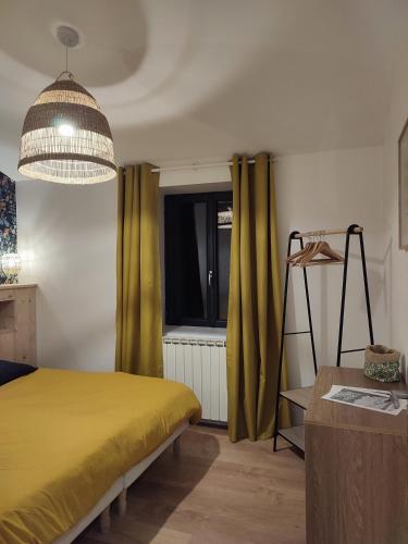 une chambre avec un lit jaune et une fenêtre dans l'établissement Le Petit Bivouac, à Saint-Bauzille-de-Putois