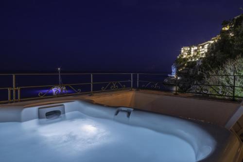 a bath tub on top of a balcony at night at Hotel Aurora in Amalfi