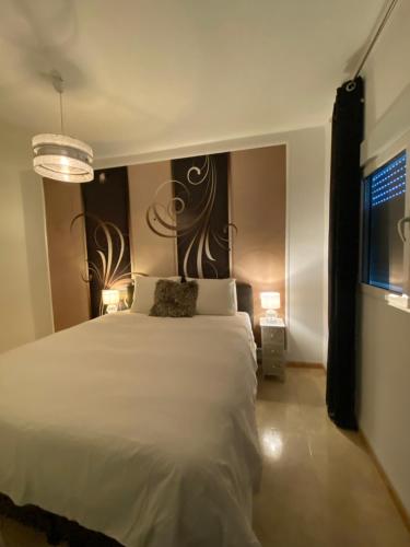 a bedroom with a white bed and a chandelier at Cortijo Los Corazones in Cantoria