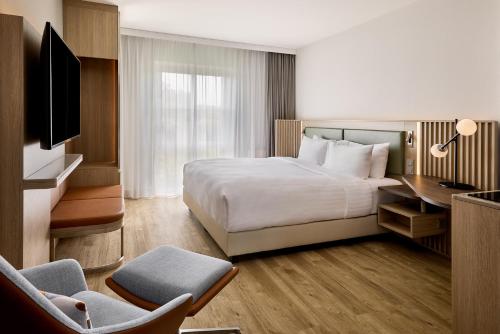 a hotel room with a bed and a desk at Courtyard by Marriott Magdeburg in Barleben