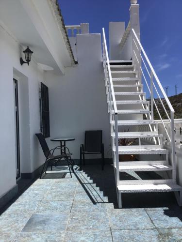 a staircase in a white building with a table and chair at Cortijo Los Corazones in Cantoria