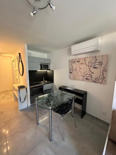 une salle à manger avec une table en verre et une cuisine dans l'établissement Superbe studio climatisé sur le port de Hyeres, à Hyères