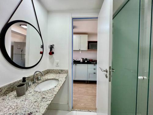 ein Badezimmer mit Waschbecken und Spiegel in der Unterkunft Terraço, Aconchegante, Gym, Ar, WiFi, PUCRS, Pet in Porto Alegre