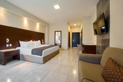 a hotel room with a bed and a couch at Hotel Estancia Business Class in Guadalajara