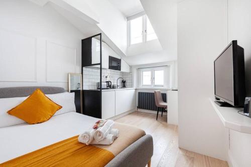 a white bedroom with a bed and a kitchen at Fabulous Studio in Paddington - 22 in London