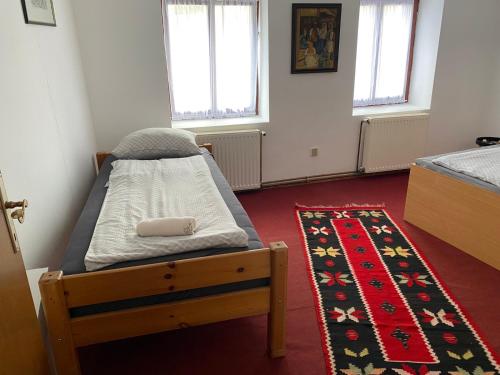 a bedroom with a bed and a rug at Apartman ''Trg'' in Tuzla