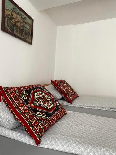 two beds in a room with red and white pillows at Apartman ''Trg'' in Tuzla