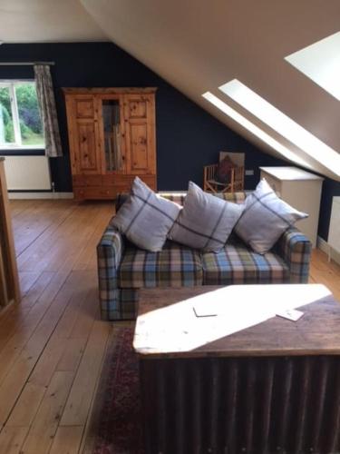 a living room with a couch with pillows at A Tranquil Retreat for Two in Pont-Robert