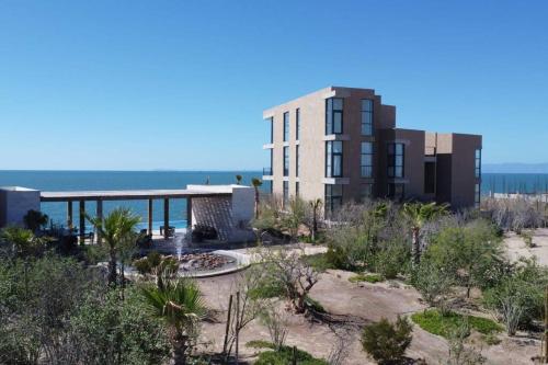 a building on the beach next to the ocean at Precioso departemento en Kino in Bahía Kino
