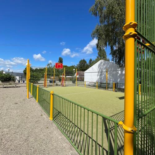 un court de tennis avec des poteaux jaunes sur un court de tennis dans l'établissement Le C24 - Charmant bungalow tout équipé pour 4 avec TV, à Boofzheim