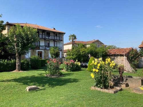 une cour fleurie et une maison en arrière-plan dans l'établissement La Maison d'Amalaurille, à Saint-Gaudens