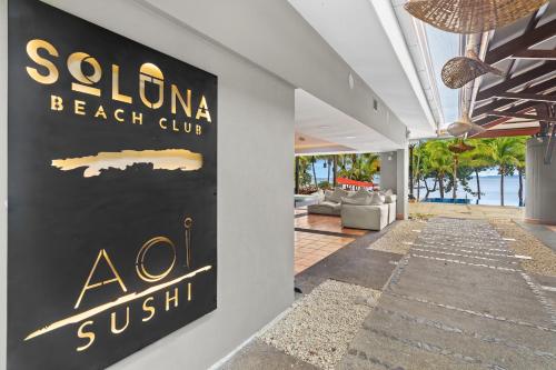 a sign for a beach club on the side of a building at Bahia Pez Vela Resort in Ocotal