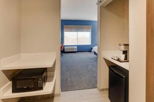 a small kitchen with a microwave and a room at Holiday Inn Express Holly Springs - Raleigh Area by IHG in Holly Springs