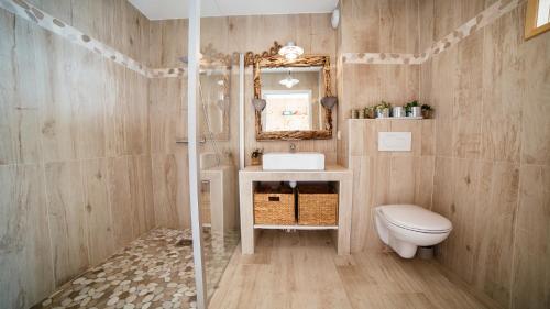 une salle de bain avec un lavabo, des toilettes et un miroir dans l'établissement Cabane bois bord de l'eau, à Gujan-Mestras