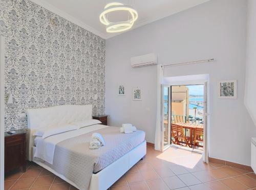 a white bedroom with a bed and a balcony at A casa di Rino in Nettuno