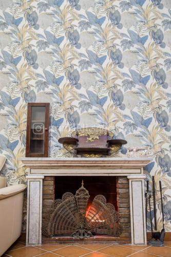 a fireplace with a blue and white floral wallpaper at A casa di Rino in Nettuno