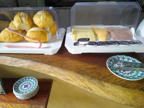 two trays of food on a table with bread and cheese at Pousada Prumirim Surf Suítes in Ubatuba