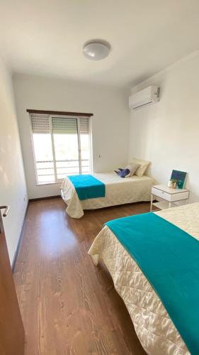 a bedroom with two beds and a window in it at Rooms in Faro close to airport in Faro