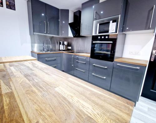 a kitchen with blue cabinets and a wooden counter top at Forest Hideout in Vielsalm