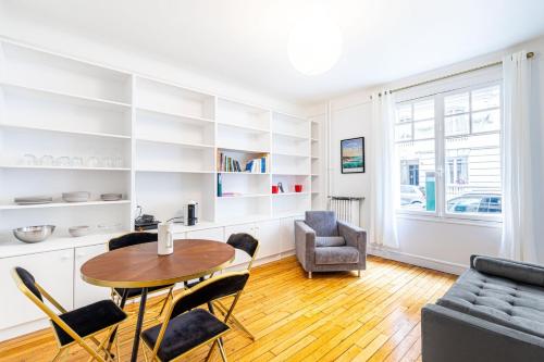 un salon avec une table et des chaises dans l'établissement GuestReady - Beautiful Getaway near Eiffel Tower, à Paris