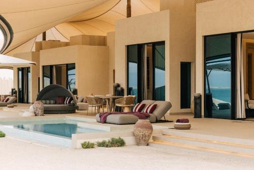 a villa with a swimming pool and a patio at Our Habitas Ras Abrouq in Dukhān