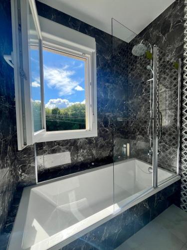 a bathroom with a bath tub and a window at A de Carmiña in A Coruña