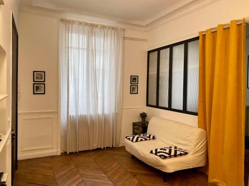 - un salon avec un canapé blanc et une fenêtre dans l'établissement Charmant appartement Paris 8., à Paris