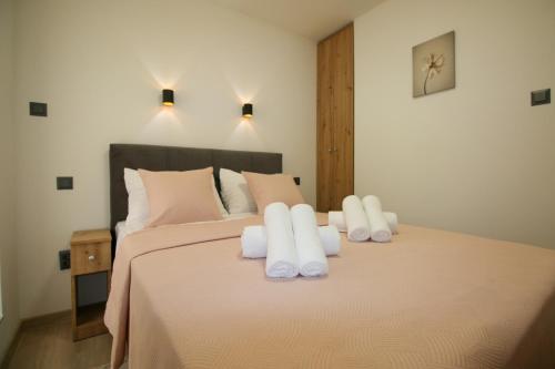 a bedroom with a large bed with white pillows at Family House Bubalo in Opuzen