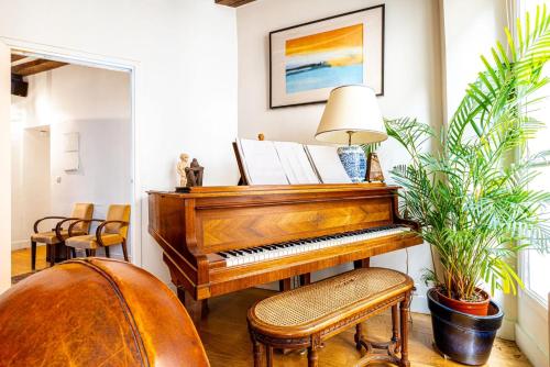 un piano dans un salon avec des plantes dans l'établissement GuestReady - Stone wall stay near Sainte-Chapelle, à Paris