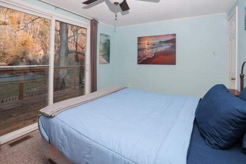 a bedroom with a bed and a large window at Serenity Awaits on Buffalo Creek in Glasgow
