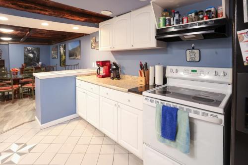 a kitchen with white cabinets and a stove top oven at Pool-Table-Hot Tub-Fire Pit in Glasgow