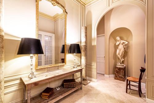 une pièce avec un miroir et une statue de femme dans l'établissement GuestReady - Séjour en famille - Arc de Triomphe, à Paris