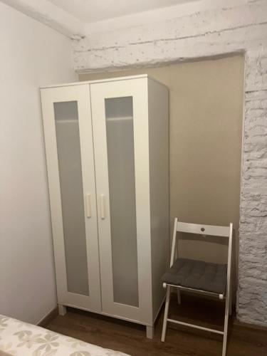 a bedroom with a white cabinet and a chair at Casa Latre Somontano in Barbastro