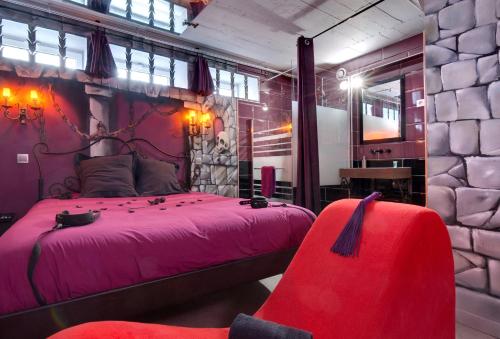 - une chambre avec un lit rose et une chaise rouge dans l'établissement Chambre Marquis de Sade, à Vichy