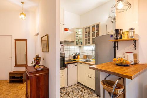 une cuisine avec des armoires blanches et un comptoir en bois dans l'établissement GuestReady - Appartement vintage à Beaugrenelle, à Paris