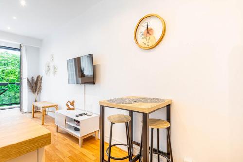 un salon avec un comptoir et une horloge murale dans l'établissement GuestReady - Homely nest with balcony, à Paris