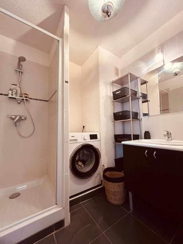une salle de bain avec une machine à laver et un lavabo dans l'établissement Eden B7 Appartement, à Saint-Tropez