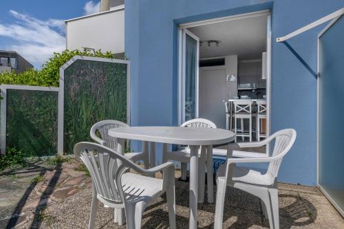 une table et des chaises sur le patio d'une maison dans l'établissement Appart avec terrasse et vue mer - 30m de la plage, à Saint-Nazaire