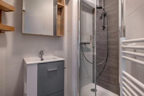 une salle de bain avec un lavabo et une douche dans l'établissement Appart avec terrasse et vue mer - 30m de la plage, à Saint-Nazaire