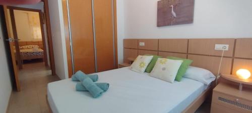 - une chambre avec un lit blanc et des oreillers verts dans l'établissement Torre la Sal - Encanto natural, à Cabanes